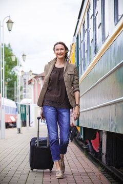 woman traveler with luggage walking on the platform