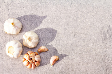 Heads of garlic on a stone background. Ingredient for cooking. Top view