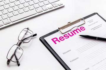 Create CV concept with pen, glasses, keyboard on white desk top view