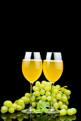 Glass of wine and grape on black background