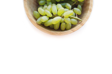 Grapes in a wooden bowl isolated on white background. Green grapes Kish Mish. Top view. 
