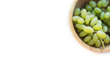 Grapes in a wooden bowl isolated on white background. Green grapes Kish Mish. Top view. 
