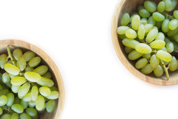 Two wooden bowls of yellow grapes on white background. Green grapes Kish Mish. Top view. Symmetry...