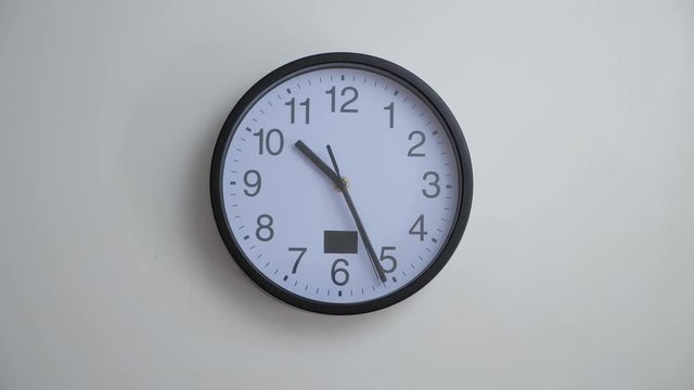 Time lapse of a big clock on a white wall.