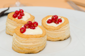 Puff pastry stuffed with vanilla cream and red currant. Vol au vent with vanilla cream and fresh fruits 