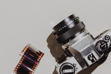 Geometric Flat lay set: vintage camera on light backgrounds with 35 mm filmstrip. Top view.