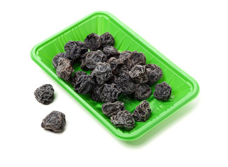 Dried black plums isolated on white background