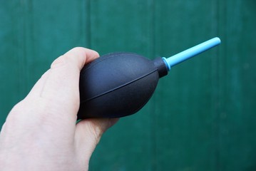 black plastic pear in his hand on a green background