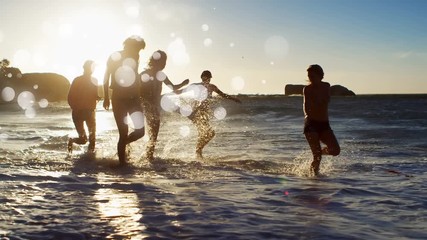 Women playing on the beach at susnet against white bubbles