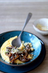 Fried mushrooms and polenta with cheese and herbs. Selective focus.