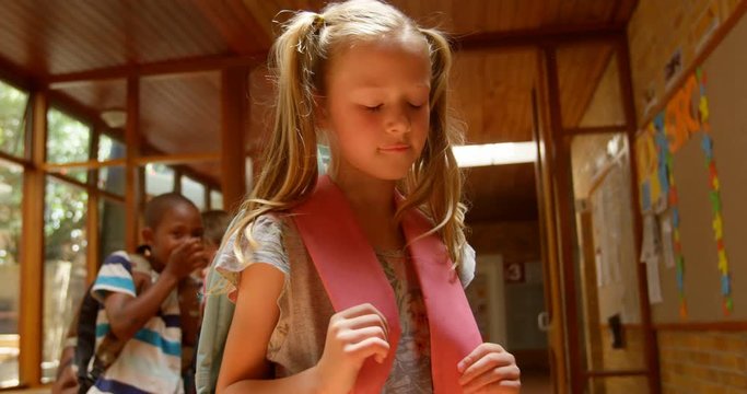 School children bullying a sad girl in corridor of elementary school 4k