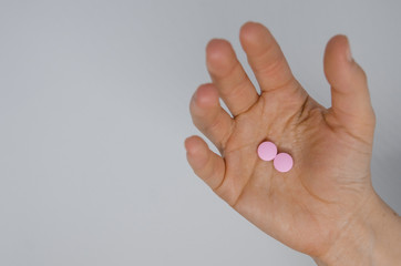 A hand with pink pills
