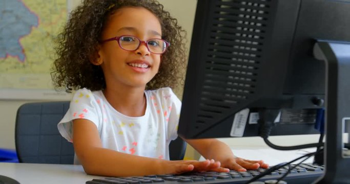 Schoolgirl using desktop pc in classroom at school 4k