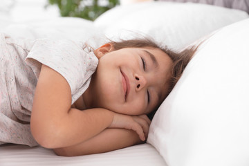 Obraz na płótnie Canvas Cute little girl sleeping on cozy bed