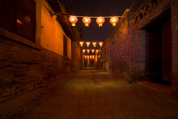 Red lanterns and bokeh at night in a street in Pingyao. The ancient city of Pingyao is a famous tourism destination. Shanxi, China