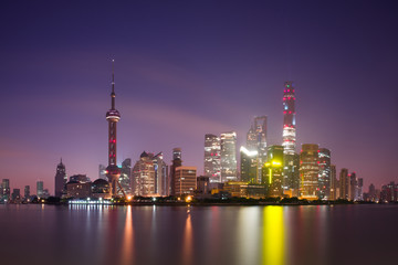 Long exposure of Pudong district, modern skyscrapers and Huangpu river in Shanghai at night. Cityscape and urban architecture in China
