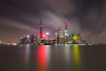 Long exposure of Pudong district, modern skyscrapers and Huangpu river in Shanghai at night. Cityscape and urban architecture in China