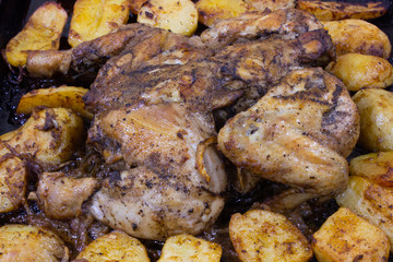 Red grilled chicken with potatoes in the oven
