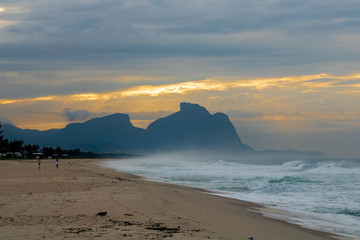 beautiful sunrise on the beach of Barra da Tijuca with the stone of Gávea in the background