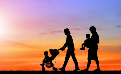 Fototapeta na wymiar silhouette happy family on the beach at sunrise time