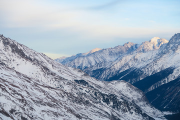 Fototapeta premium Mountain range of Caucasian Mountains in the clouds blue sky