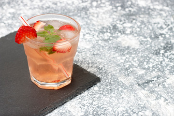 Cold summer drink with mint and strawberry on a gray background, copy space