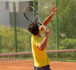 A man plays tennis on the court in the park © schankz