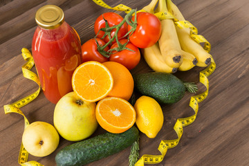 fruits, vegetables, juice, measuring tape on wooden surface