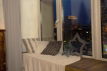 Cozy corner with pillows and warm knitted plaid on window sill. 