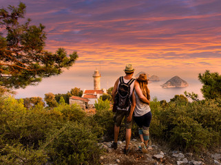 Young couple at looking at the scene at Cape Gelidonya Lighthouse during sunset