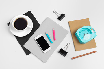 Smartphone and coffee cup, notepad close up top view