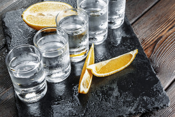 Vodka in shot glasses on rustic wood background