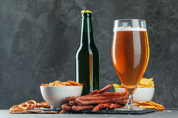  beer and appetizing beer snacks set. Table with mug of beer, wooden board with sausages