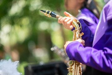 Little boy in purple white uniform play saxophone in  marching band