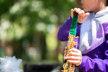 Little boy in purple white uniform play saxophone in  marching band