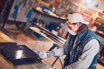 Male carpenter working on old wood in a retro vintage workshop.