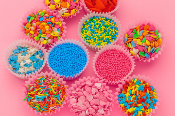 Sugar sprinkles, decoration for cake and ice-cream and cookies on pink background