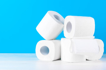 Toilet paper rolls stacked against blue background