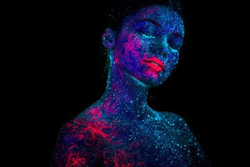 Profile portrait of a beautiful girl alien. Ultraviolet body art blue night sky with stars and pink...