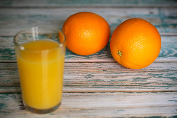 orange juice and oranges are on the table