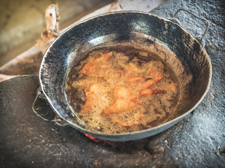 Fish fried in pan with oil in rural kitchen. Eco village Hiriwadunna, Sri Lanka, March 10, 2019.