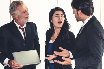 Senior caucasian manager working in office with assistance of young Asian business people and...