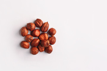 A handful of dry raw hazelnuts on a studio white background.