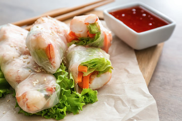 Tasty spring rolls on board, closeup