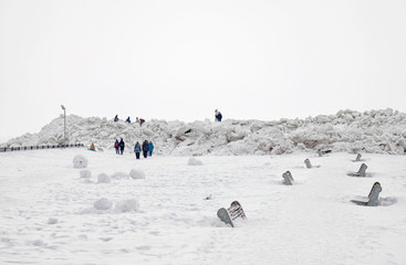 People walk near pressure ridges (ice floes) on The Gulf of Finland on the beach of Zelenogorsk Town (district of St Petersburg) in March. Russia
