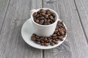 Coffee cup and coffee beans on wooden background. Top view and selective focus