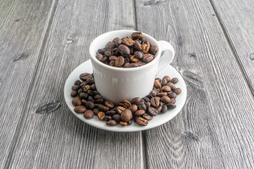 Coffee cup and coffee beans on wooden background. Top view and selective focus