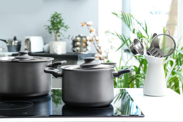 Saucepans on electric stove in kitchen