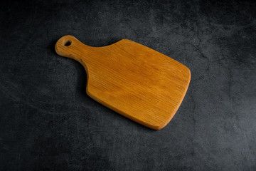 An empty wooden tray on a black background