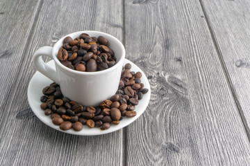 Coffee cup and coffee beans on wooden background. Top view and selective focus